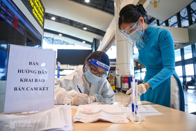 Hành khách viết cam kết phòng dịch tại sân bay Nội Bài. Ảnh: Giang Huy.